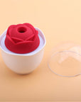 Red Nectar rose vibrator with a circular central opening in a white holder, with the clear dome cover removed and placed beside it