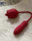 Red Rhea rose tongue vibrator and ribbed rounded opposite end separated by a flexible U-shaped cord on a white textured surface