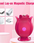 Rose pinpoint vibrator standing on a matching pink magnetic charging base with a cable exiting to the side