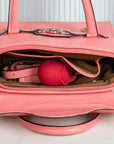 Rose tapping stimulator pictured inside an open pink handbag to illustrate its handheld form