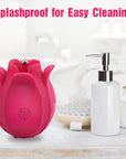 Pink rose massager with water droplets beside a soap dispenser and towel