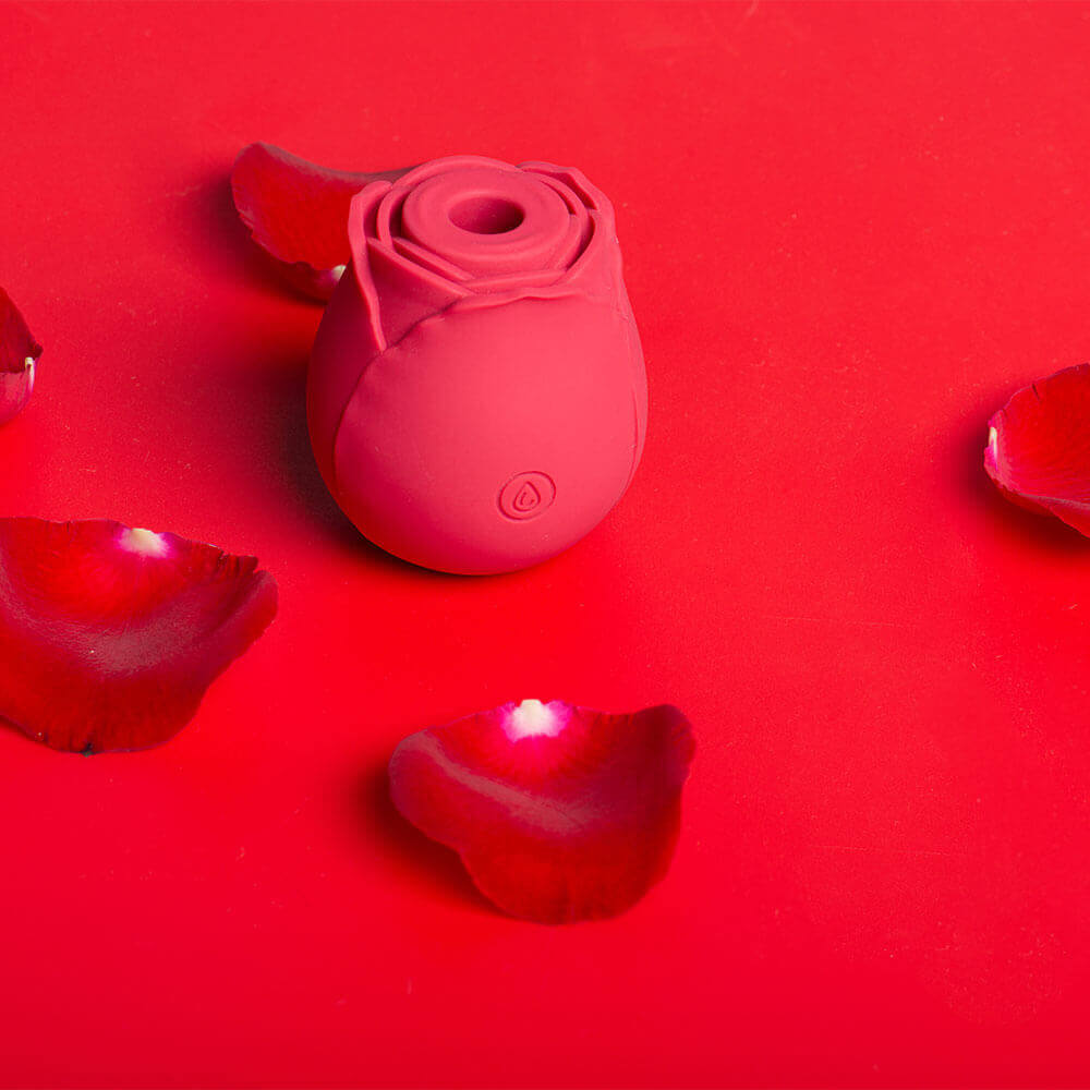 Red Rose Toy Sucking Vibrator with central opening on a background of rose petals