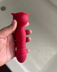 Hand holding the red rose thrusting plug to show its rounded tip, ribbed shaft, narrow neck and wider petal-shaped base