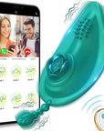 Teal wearable vibrator with a raised rose detail, dotted surface and short beaded tail, pictured beside a phone interface and two-button white remote