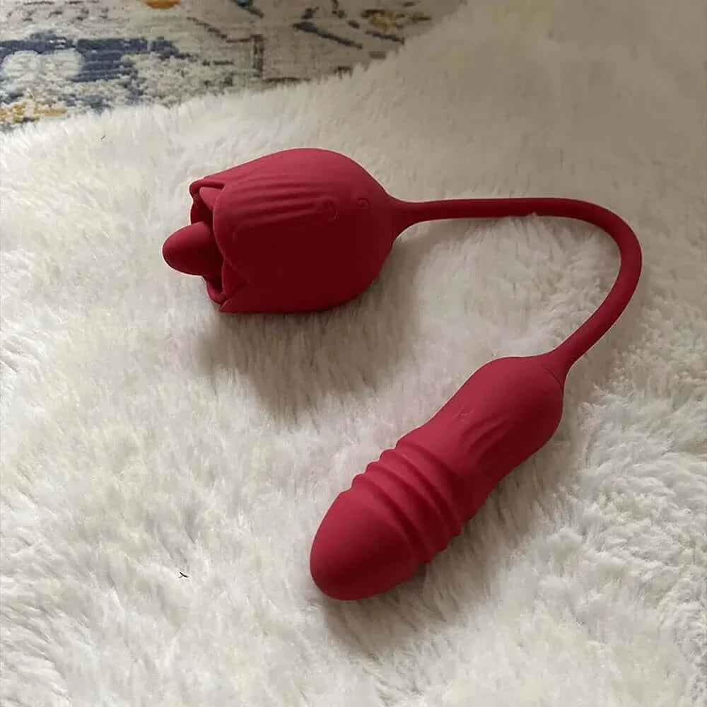 Red Rhea rose tongue vibrator and ribbed rounded opposite end separated by a flexible U-shaped cord on a white textured surface
