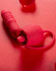 Red Rhea rose tongue vibrator with a raised tongue, curved ribbed opposite end and large loop handle arranged on a red surface