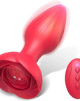 Red rose remote control vibrating plug with a tapered bud, wide petal base, underside power button and charging contacts beside a three-button remote