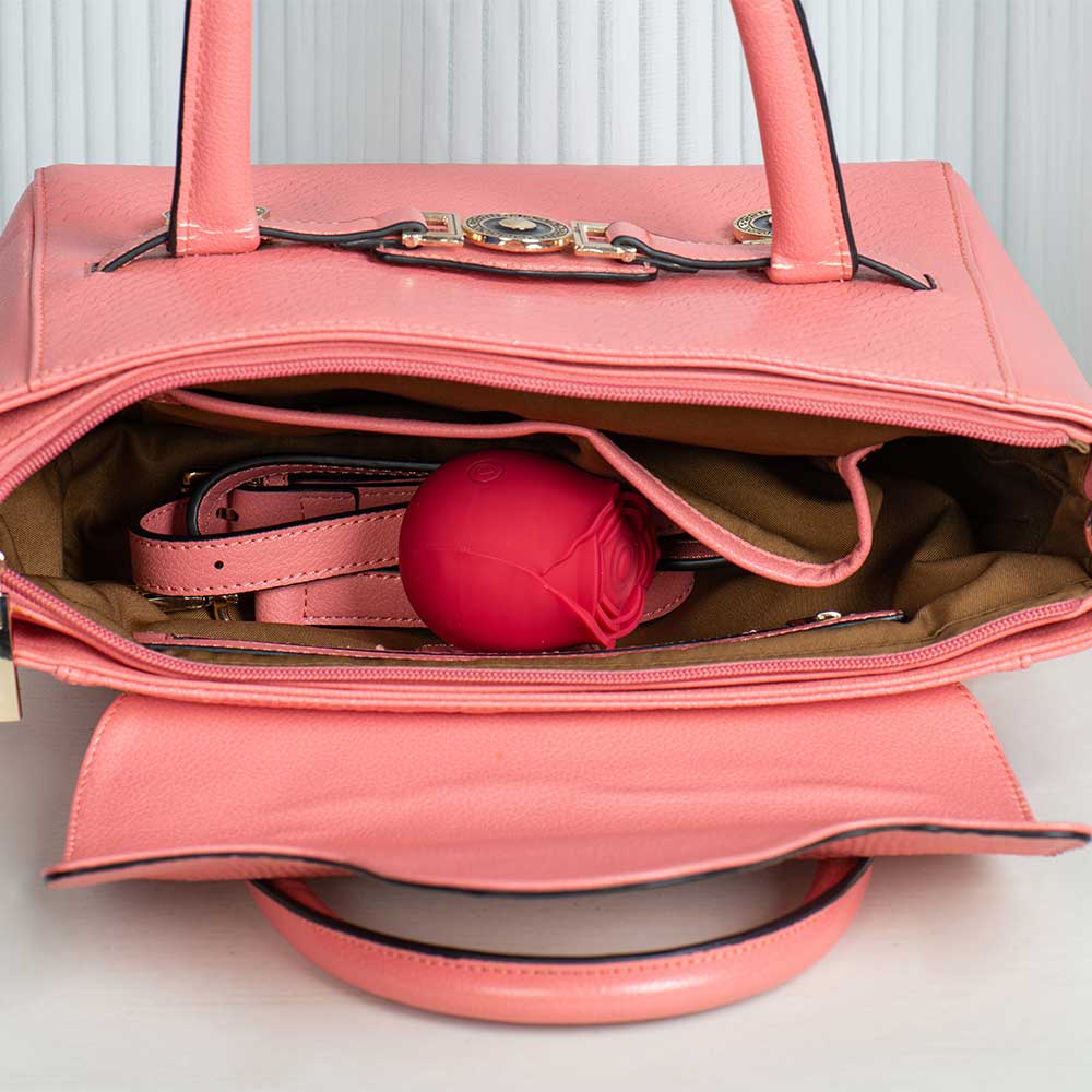 Rose tapping stimulator pictured inside an open pink handbag to illustrate its handheld form
