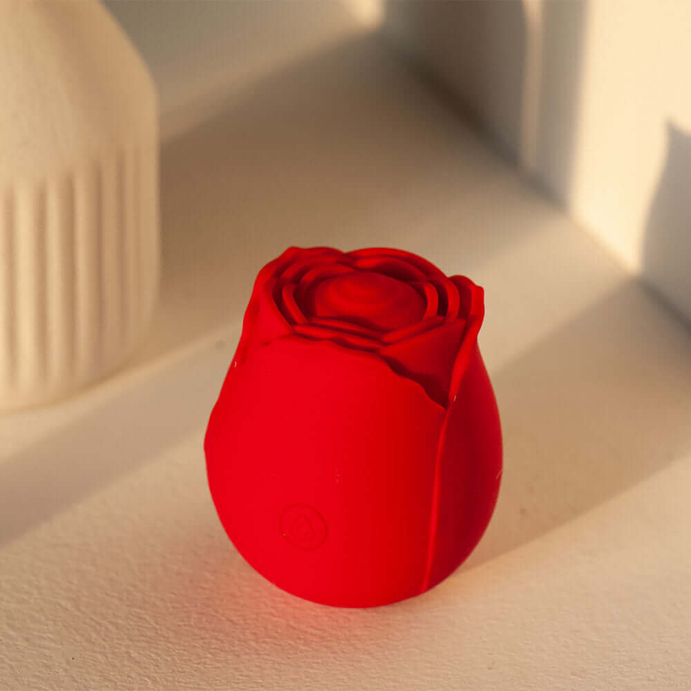 Red rose tapping stimulator with layered petals, a broad rounded central pad and one front power button