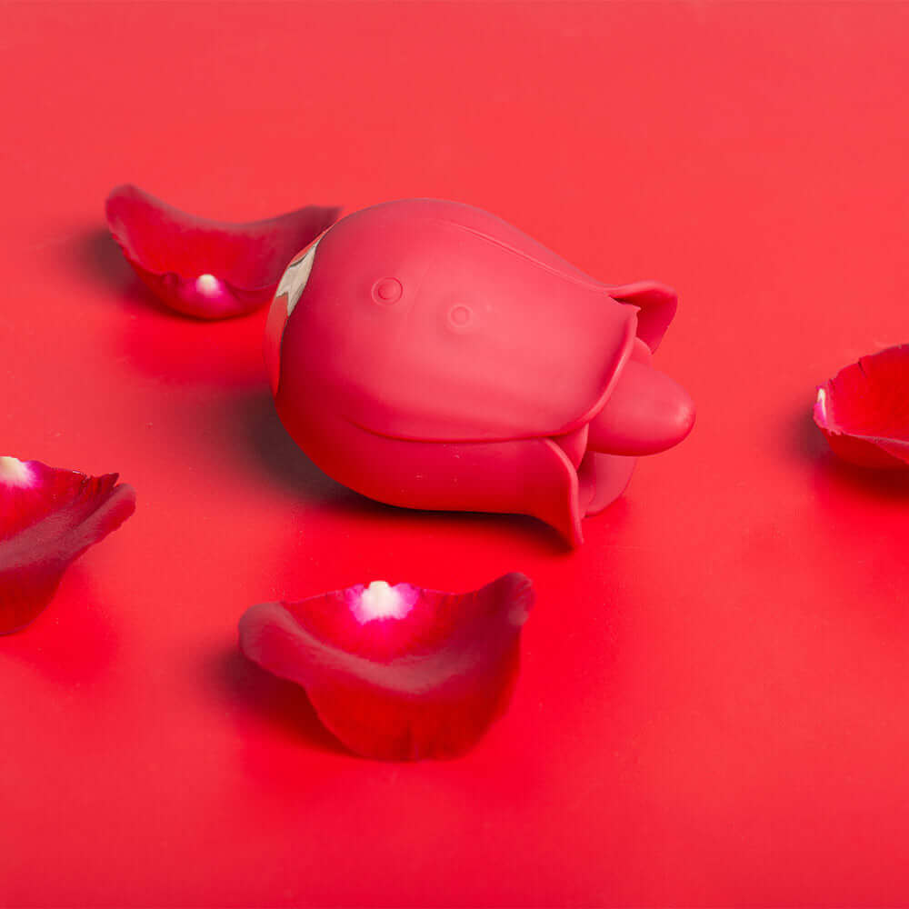 Red compact rose tongue vibrator lying on its side, showing two circular control buttons, a raised tongue and a gold-colored base